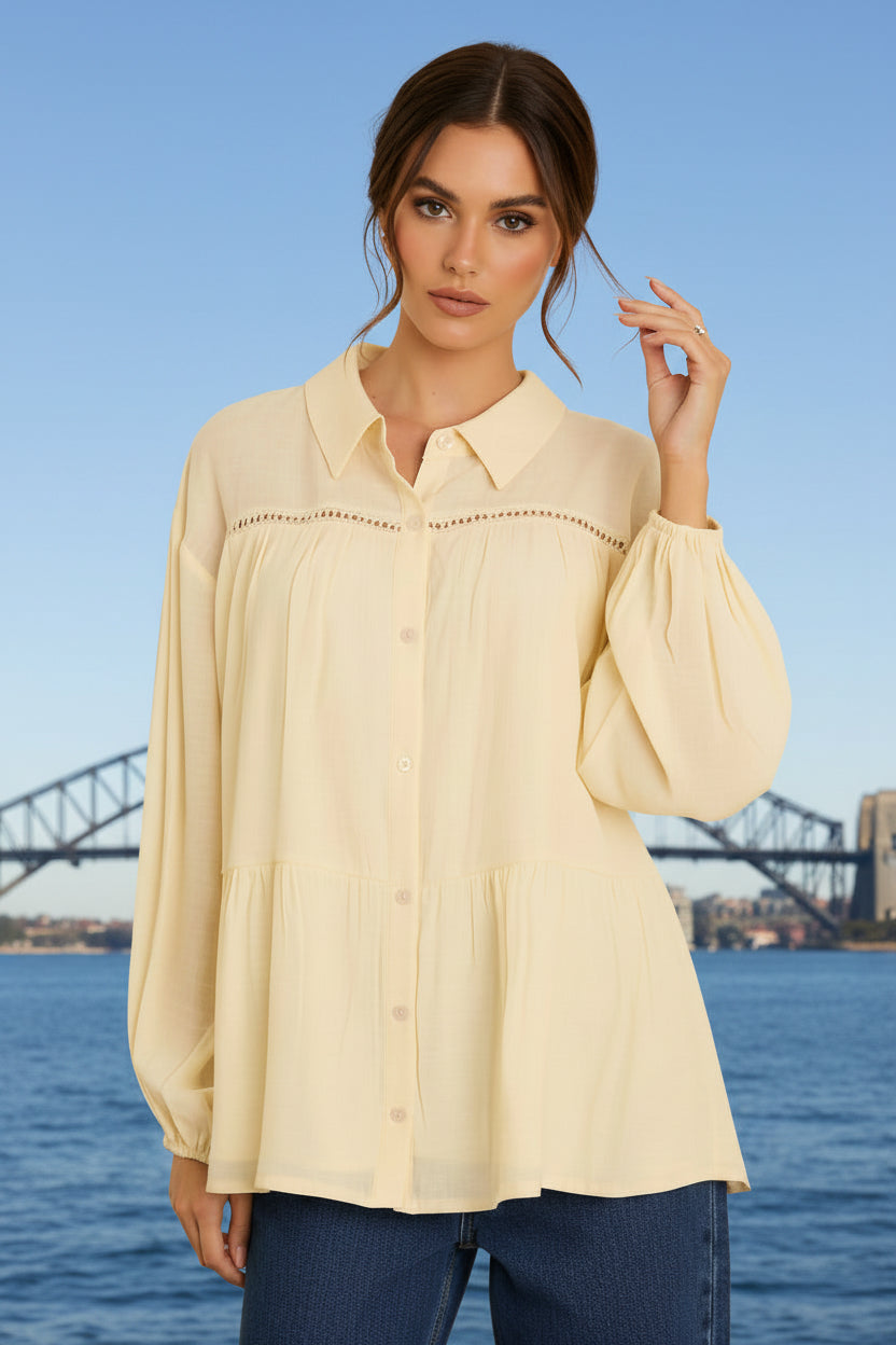 Woman wearing a white blouse with a scenic background of the Sydney Opera House and Harbour Bridge.