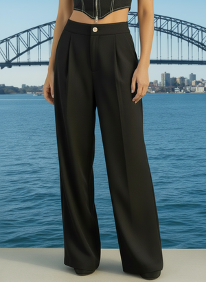 Person wearing black wide-leg pants with a city skyline and bridge in the background