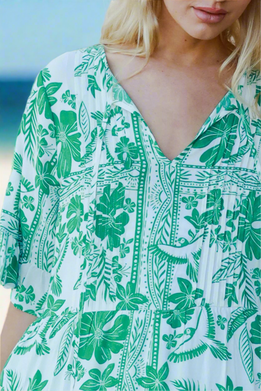 Woman wearing a green and white floral dress with a blurred background