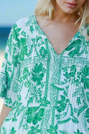 Woman wearing a green and white floral dress with a blurred background