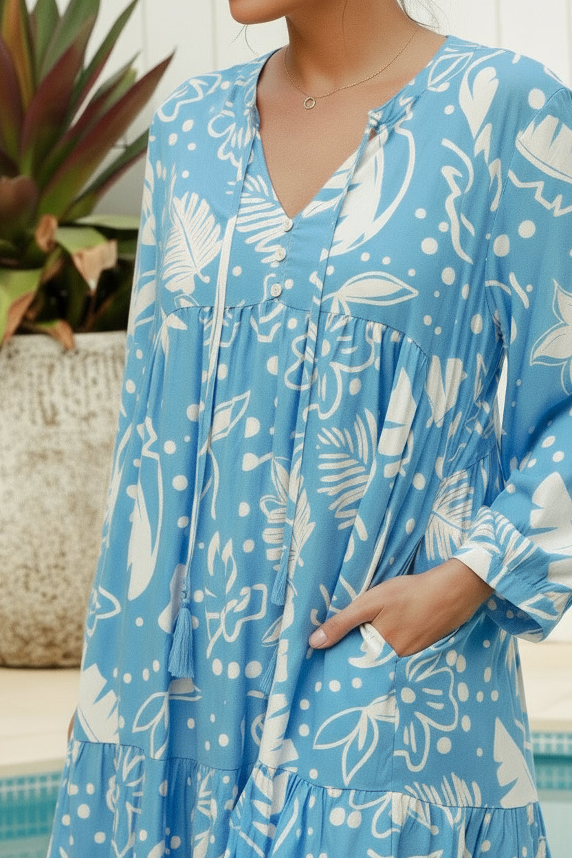 Woman wearing a blue floral dress by a poolside