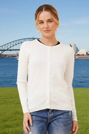 Woman wearing a white cardigan and blue jeans standing in front of the Sydney Harbour Bridge.
