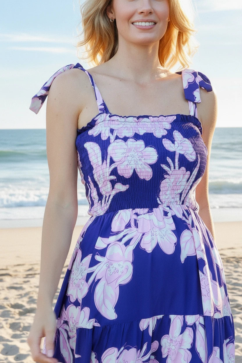 Woman wearing a blue floral dress on a beach