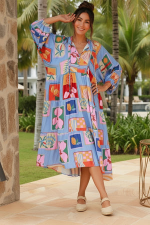 Woman in a colorful dress standing outdoors with palm trees in the background