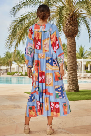 Woman wearing a colorful dress with a palm tree and pool in the background
