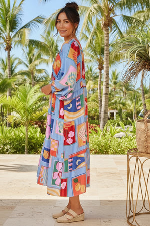 Woman in a colorful dress standing in a tropical setting with palm trees.
