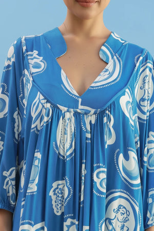 Blue dress with white patterns worn by a person, with a blurred background