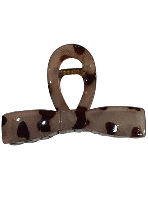 Brown and white patterned hair clip on a white surface