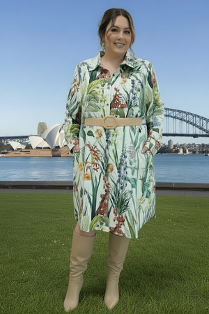 Woman in a floral shirt dress with a belt standing in front of the Sydney Opera House and Harbour Bridge.