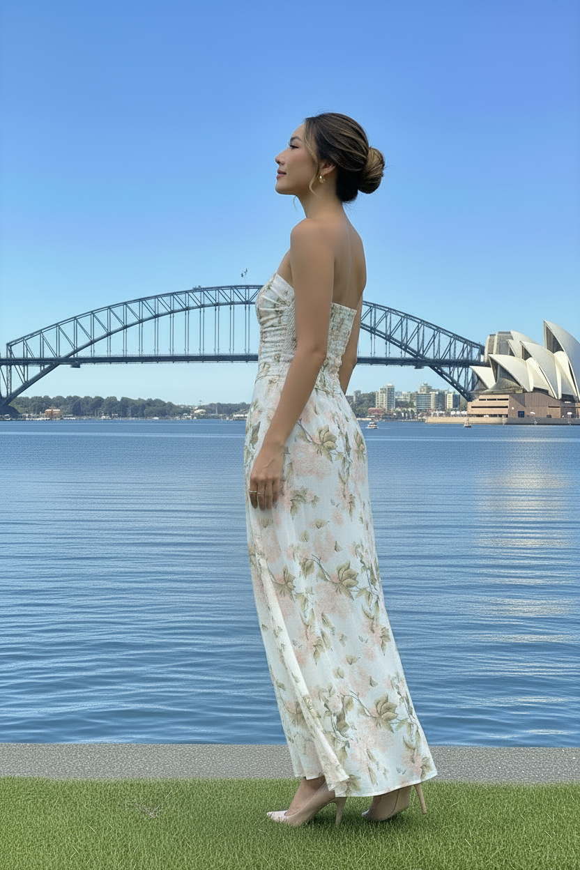 Woman in a floral dress standing in front of the Sydney Harbour Bridge and Opera House.