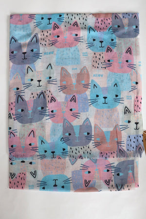 Patterned fabric with colorful cat faces on a white background