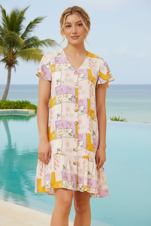 Woman in a colorful dress standing by a pool with palm trees in the background