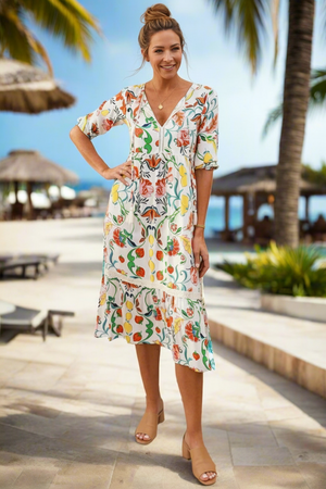 Woman in a floral dress standing by a poolside with palm trees in the background
