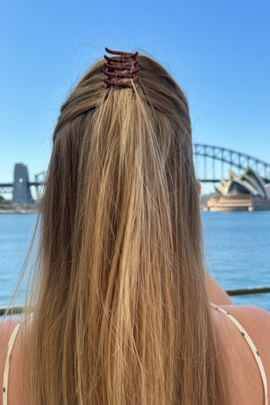 Person with long blonde hair wearing a hair clip against