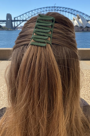 Person with long hair and a green hair clip 