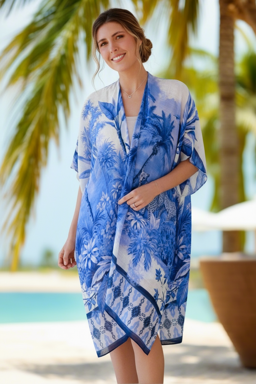 Woman wearing a blue and white floral kimono-style cover-up in a tropical setting.