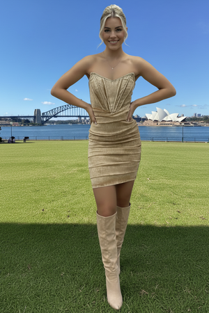 Woman in a stretch denim corset dress and beige knee-high boots