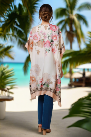 Woman wearing a floral kimono on a beach with palm trees and ocean view
