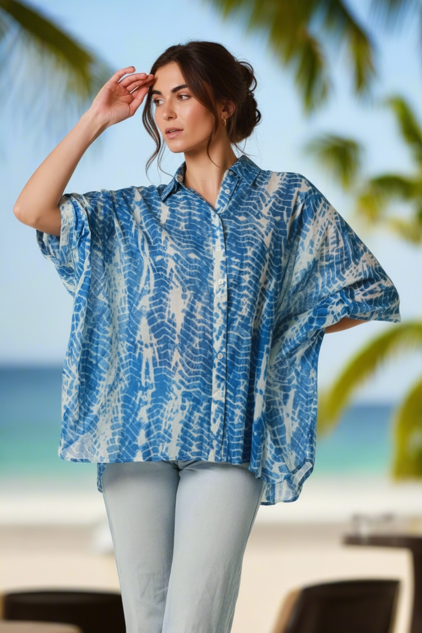 Woman wearing a blue and white patterned shirt by the beach