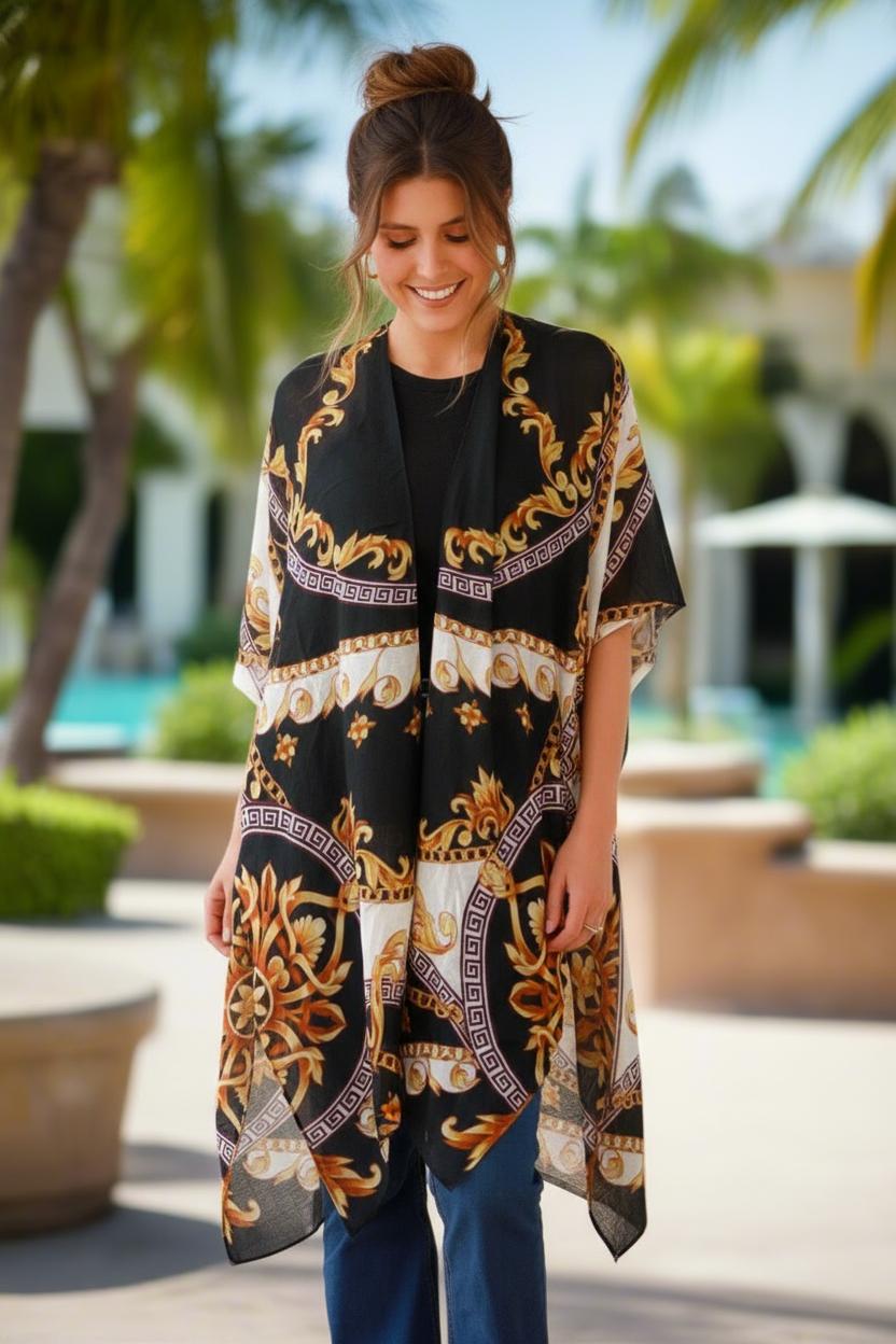 Woman wearing a patterned black and gold scarf outdoors with palm trees and a pool in the background