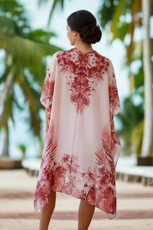 Woman wearing a floral kimono-style garment with palm trees in the background