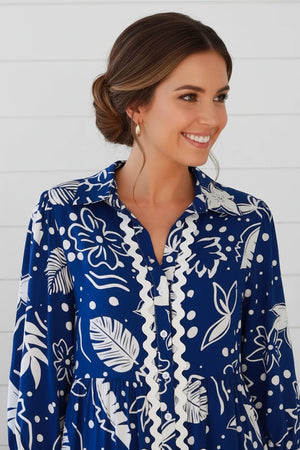 Woman wearing a blue and white floral patterned dress against a white background