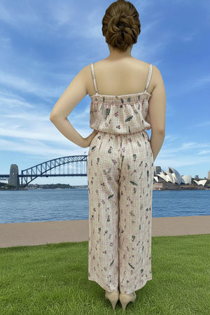 Person wearing a patterned jumpsuit with a scenic background of a bridge and Opera House.