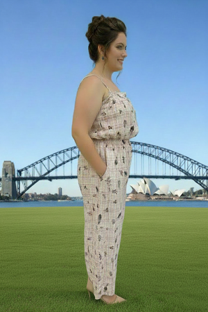 Woman in a patterned outfit standing on grass with the Sydney Harbour Bridge and Opera House in the background.