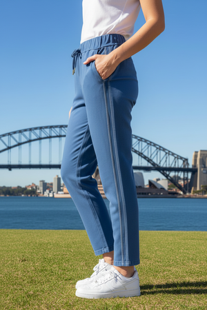 Person wearing drawer string blue pants with vertical sequins stripes on the side