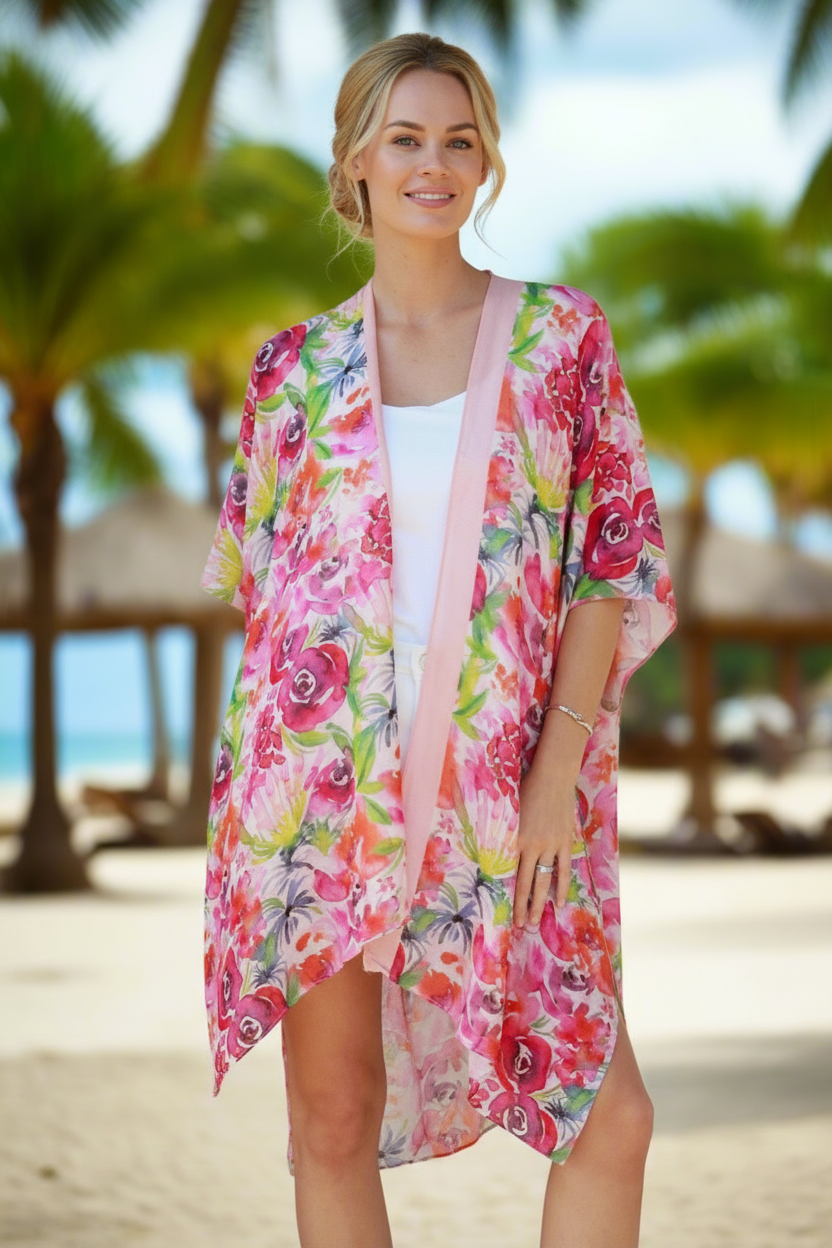 Woman wearing a colorful floral kimono on a beach with palm trees in the background