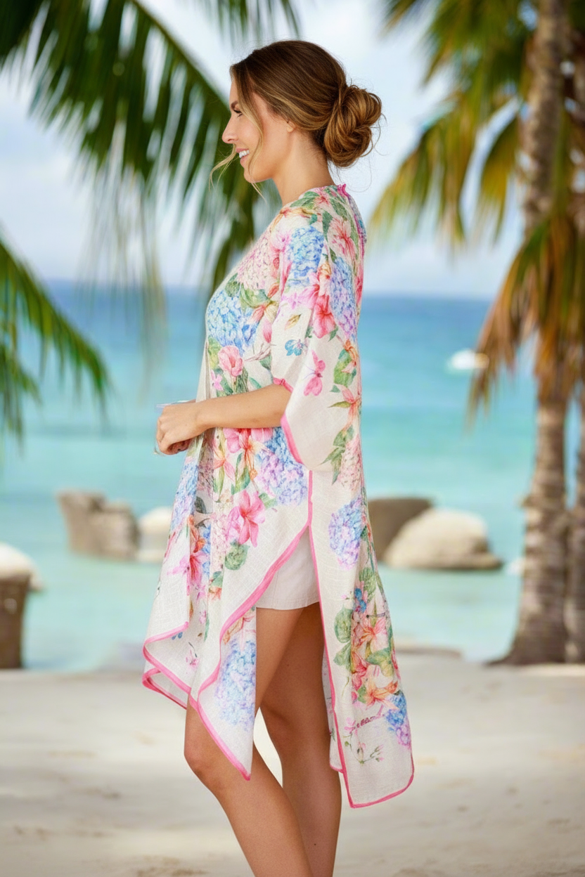 Woman wearing a colorful floral cover-up by a pool with palm trees in the background