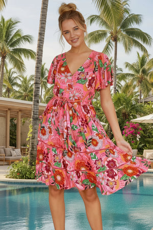 Woman wearing a pink floral dress in an indoor setting