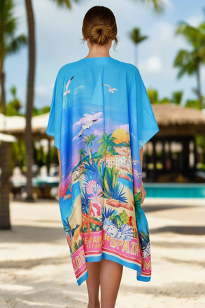 Woman wearing a colorful beach cover-up with palm trees and a pool in the background.