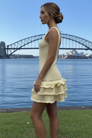 Woman in a yellow backless dress standing by the water with the Sydney Harbour Bridge in the background
