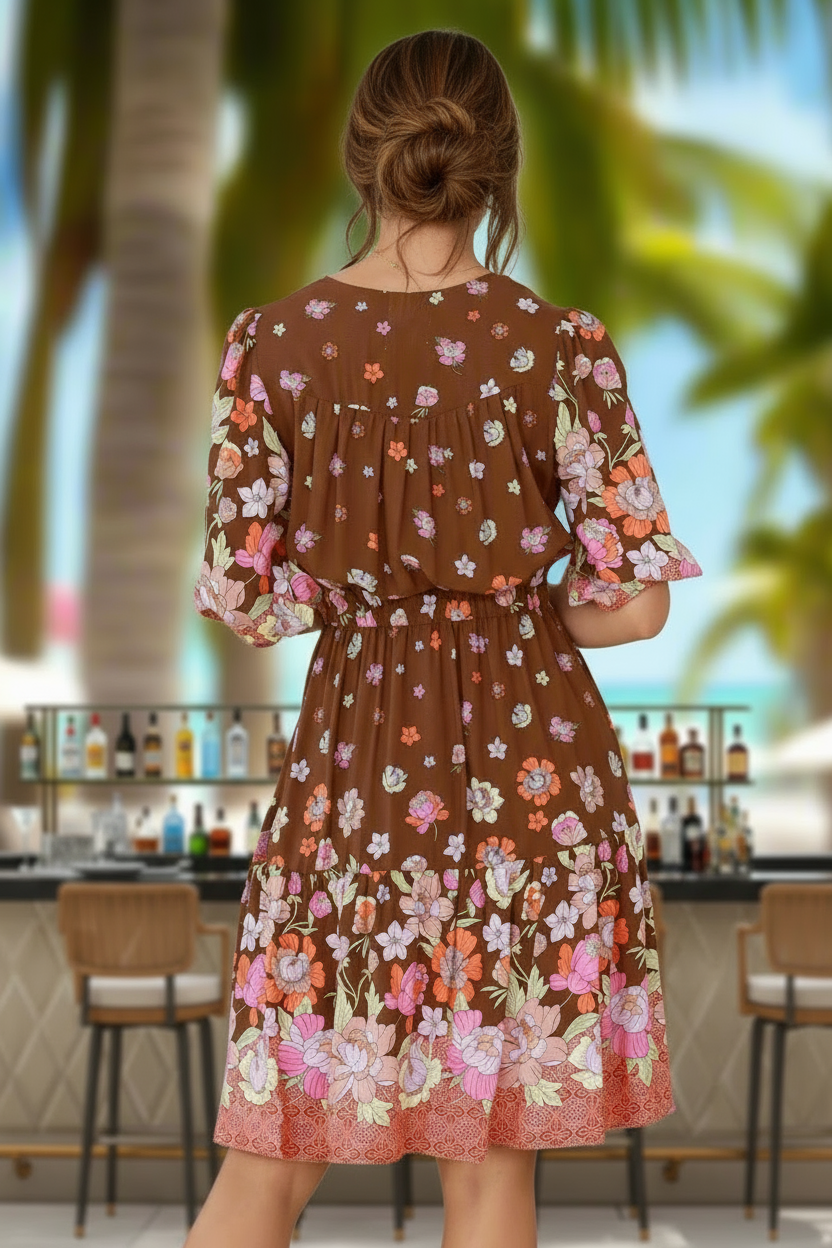 Woman wearing a brown floral dress in a tropical setting with palm trees and a bar.