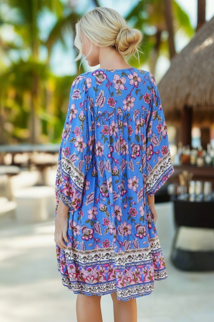 Woman wearing a blue floral dress in a tropical setting