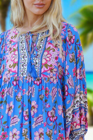 Woman wearing a blue floral dress with a blurred background