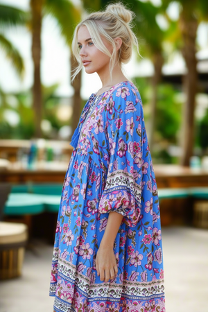 Woman wearing a blue floral dress in a tropical setting
