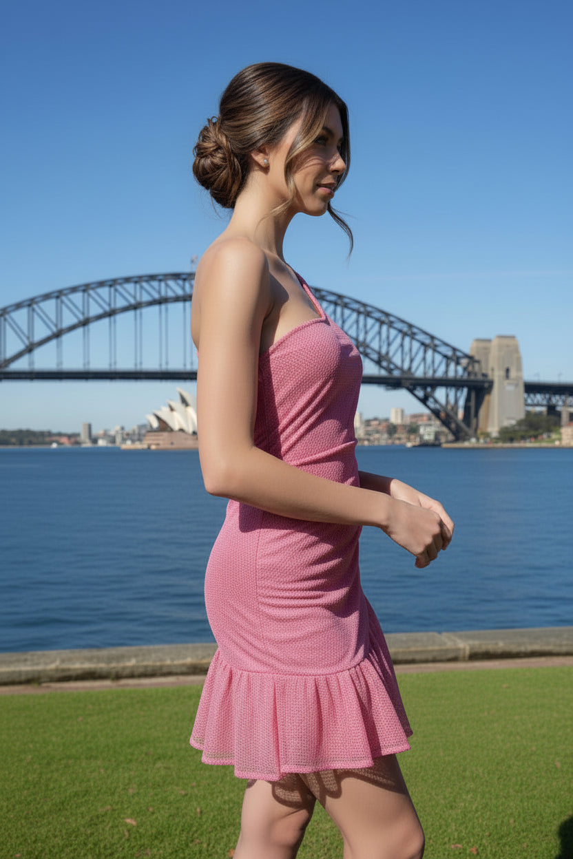 Woman in a pink net dress standing in front of the Sydney Harbour Bridge and Opera House.