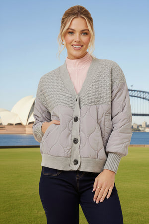 Woman wearing a light gray quilted cardigan 