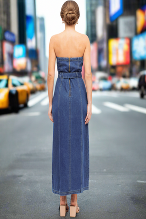 Woman wearing a strapless denim dress on a city street with blurred background
