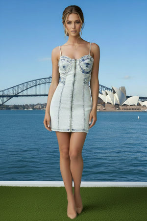 Woman in a denim dress standing in front of the Sydney Harbour Bridge and Opera House.