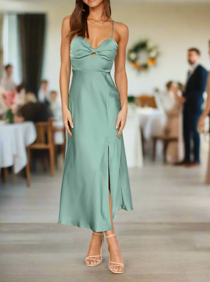 A woman wearing a green satin midi cocktail dress with a sweetheart neckline, front keyhole, and back zipper, standing at a social event.
