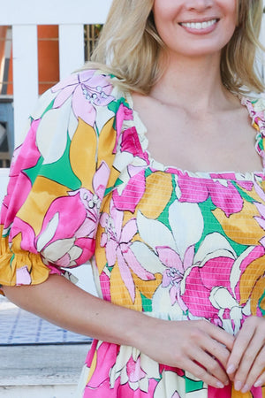 Woman wearing a colorful floral dress with a blurred background
