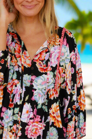 Woman wearing a colorful floral dress with a blurred natural background