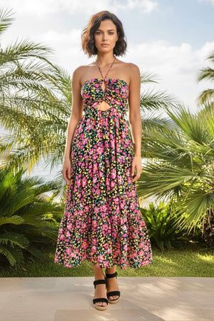 Woman wearing a floral dress standing in a tropical setting with palm trees.