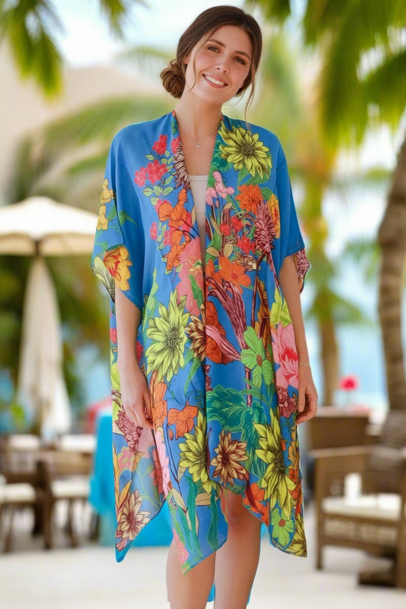 Woman wearing a colorful floral kimono at a beachside location.
