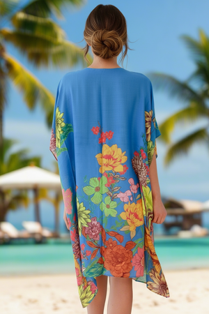 Woman wearing a colorful floral kimono on a beach with palm trees in the background