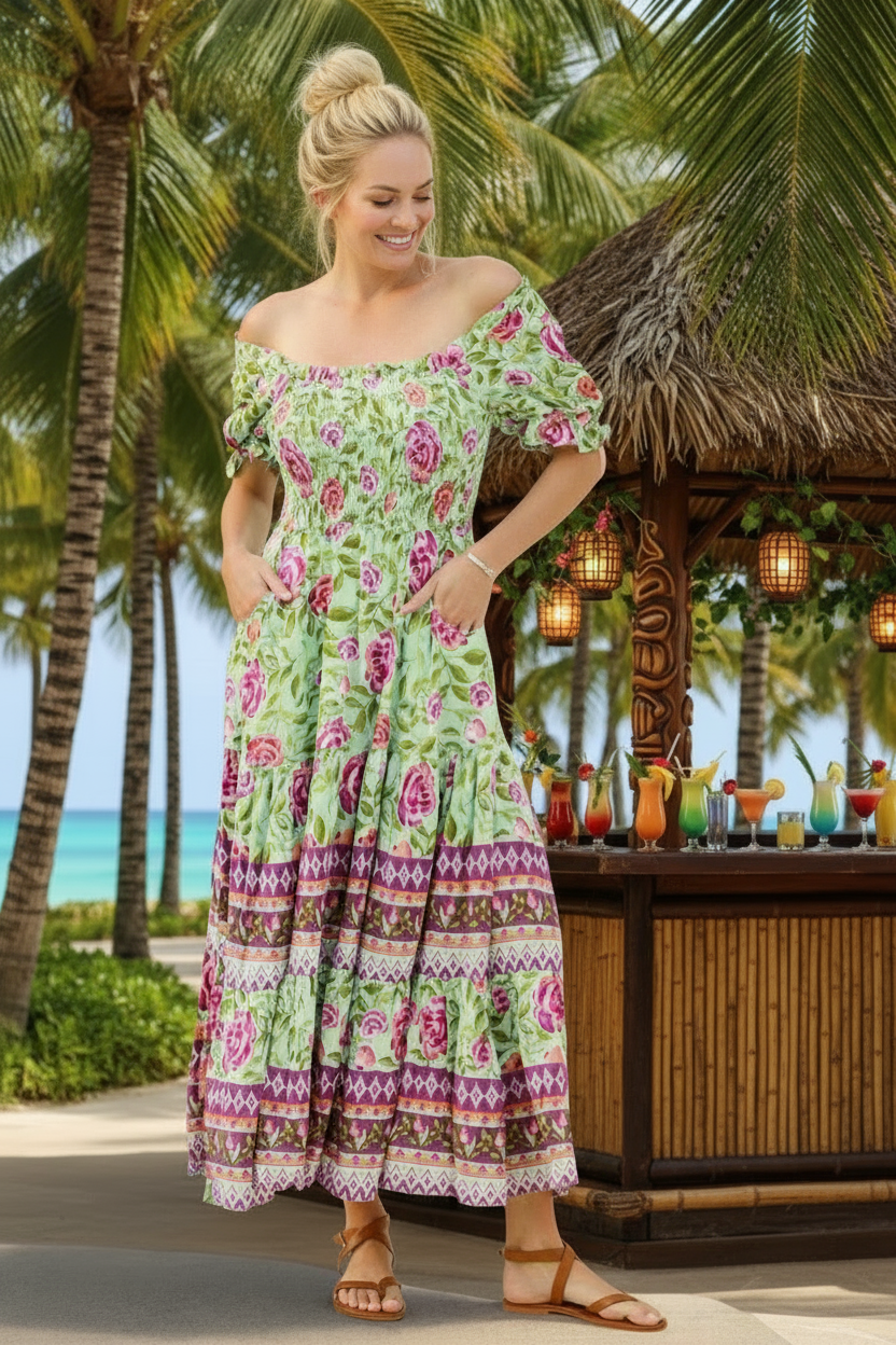 Woman in a floral dress standing by a tropical bar with palm trees in the background