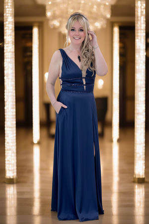 Woman in a blue evening gown standing in a decorated room with lights.